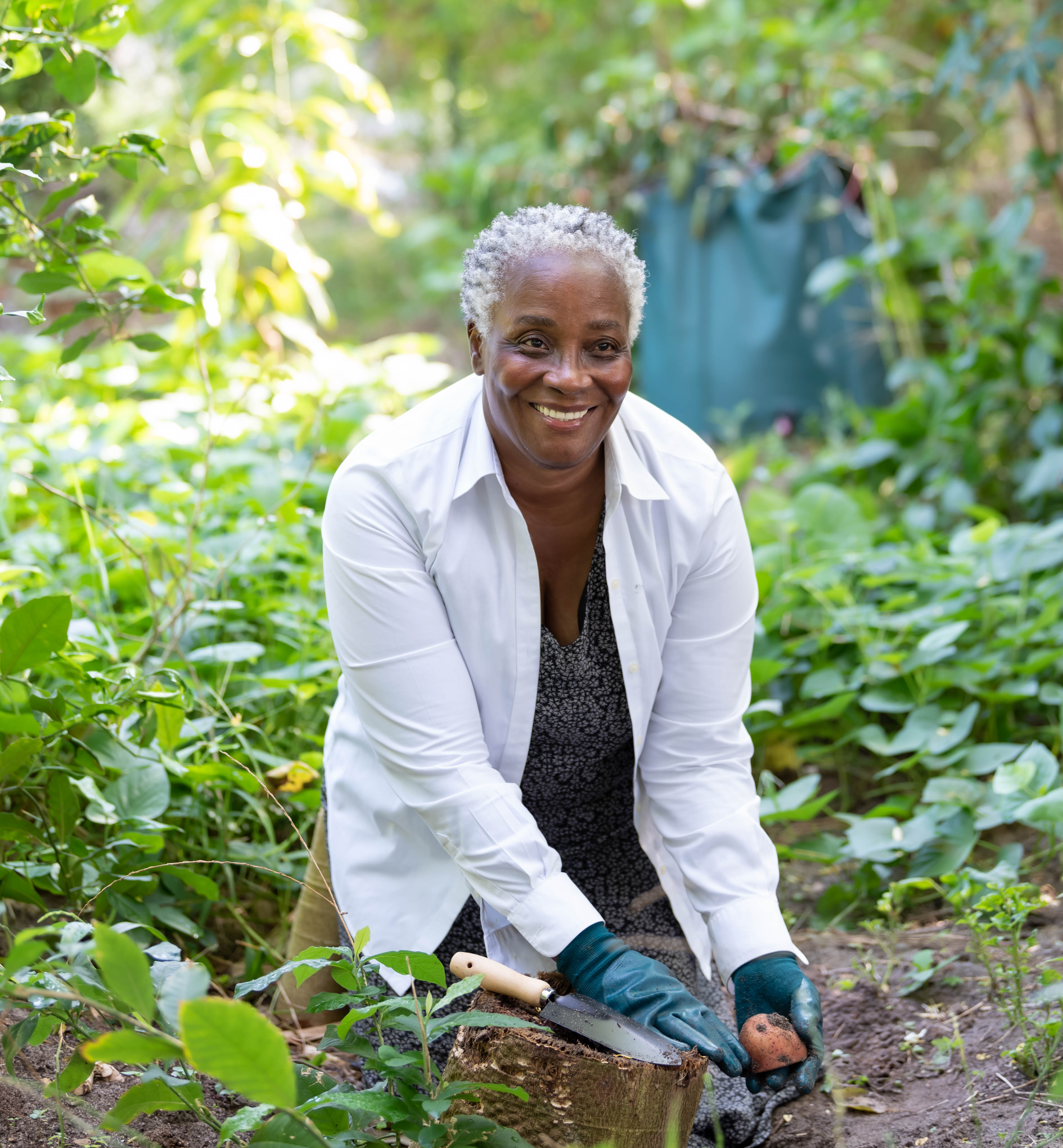 Pauline tending established plants in a South Brevard garden